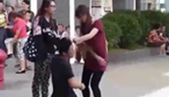 Woman forces boyfriend to kneel in street and repeatedly slaps him